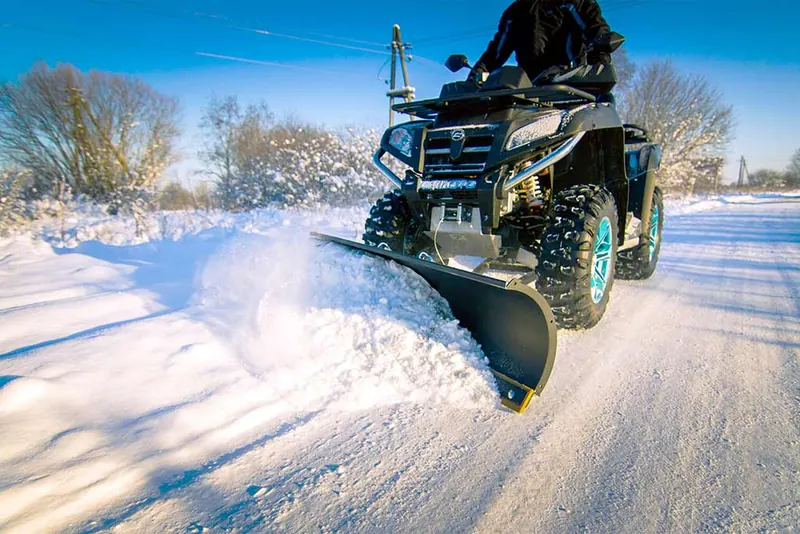 Quad z pługiem Iron Baltic odśnieża drogę