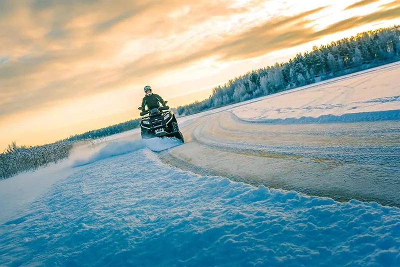 Quad z pługiem Iron Baltic odśnieża drogę o zachodzie słońca